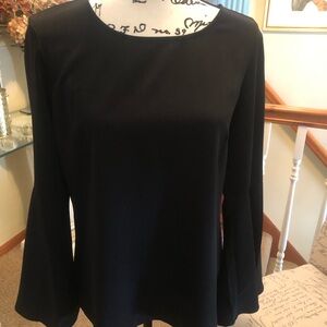 Lines black top with bell sleeves with open detail in back.